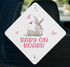 A white diamond-shaped sign with a cartoon rabbit and the text "BABY ON BOARD" printed on it.