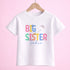 A white t-shirt with the text "BIG SISTER Sadie" printed on it, along with colorful flower designs.