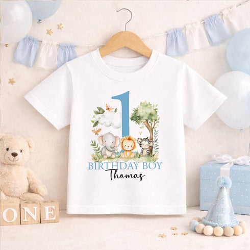 Personalised 1st birthday boy outfit with blue number 1, safari animals, elephant, lion, zebra, tree and custom name, shown on bib, vest, sleepsuit, t-shirt and white pyjamas.