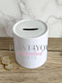 a white trash can sitting on top of a wooden table