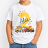 A child wearing a white short-sleeve T-shirt with a colorful custom graphic on the front. The graphic features a large yellow number 2 decorated with stars, the name 'Alex' in blue script, and a row of cartoon construction vehicles including a yellow dump truck, a red tanker, and a blue car.