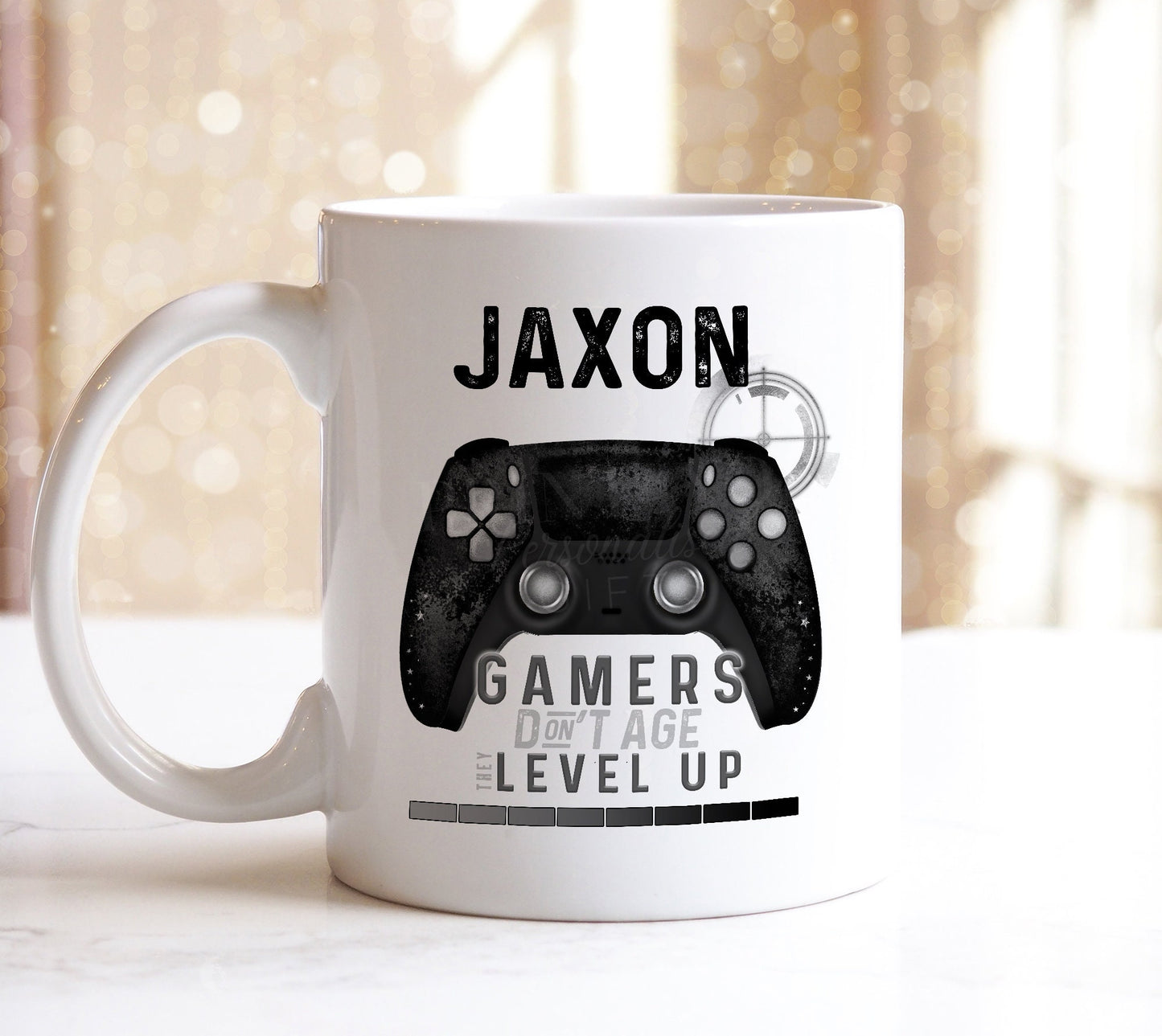 White ceramic mug with contrasting black handle, printed with a controller graphic and 'Gamers don't age they level up' text