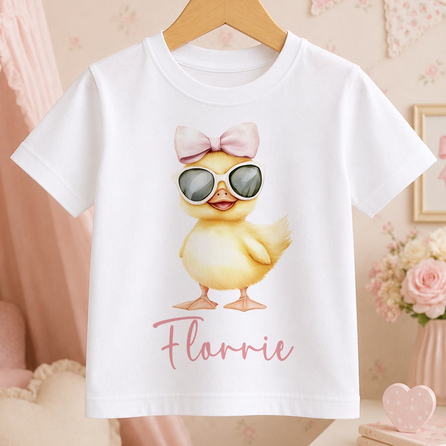A white t-shirt with a cartoon image of a yellow duck wearing sunglasses and a bow on its head, along with the name "Flarnie" printed below.