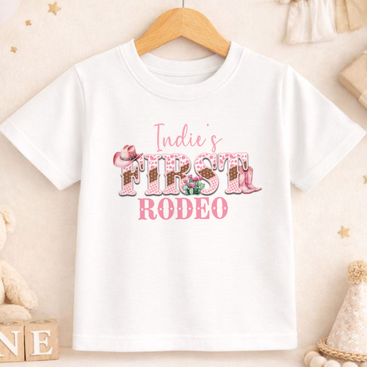 Personalised pink cowgirl first rodeo t-shirt, printed with your baby's name.