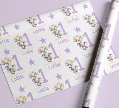 Sheet of personalised purple elephant 1st birthday wrapping paper laid flat