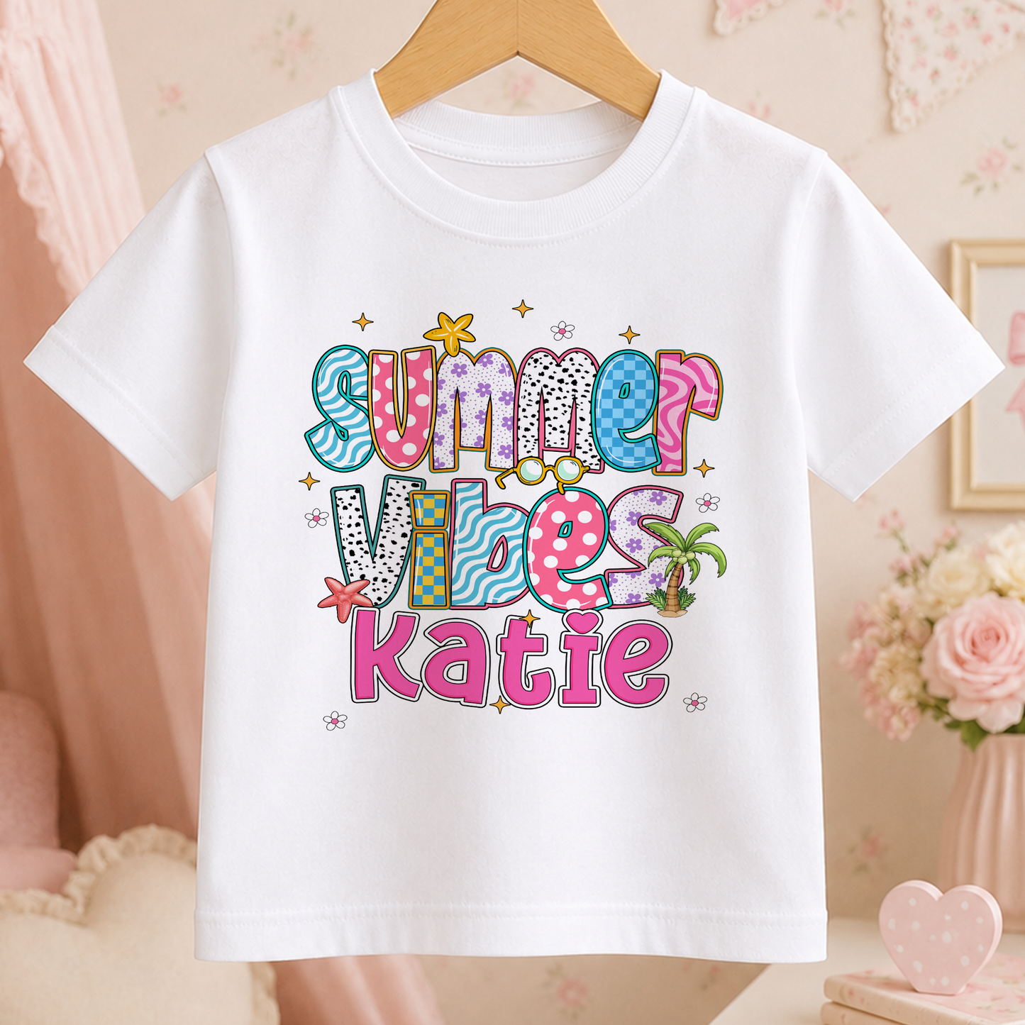 A white t-shirt with a colorful, playful design that says "Summer Vibes Katie" printed on it.