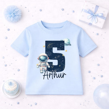 Blue children's t-shirt with a personalised astronaut space birthday design, laid flat, front view