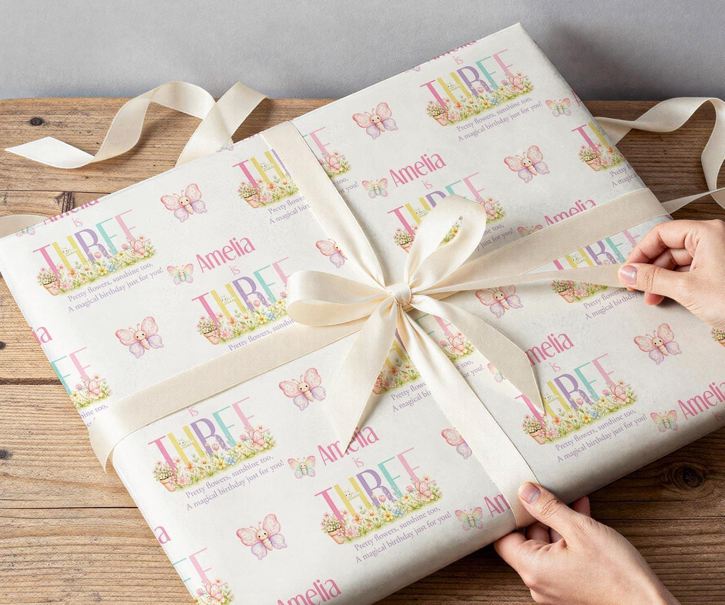 Close-up of the pastel butterfly wrapping paper pattern showing the personalised name and age detail.