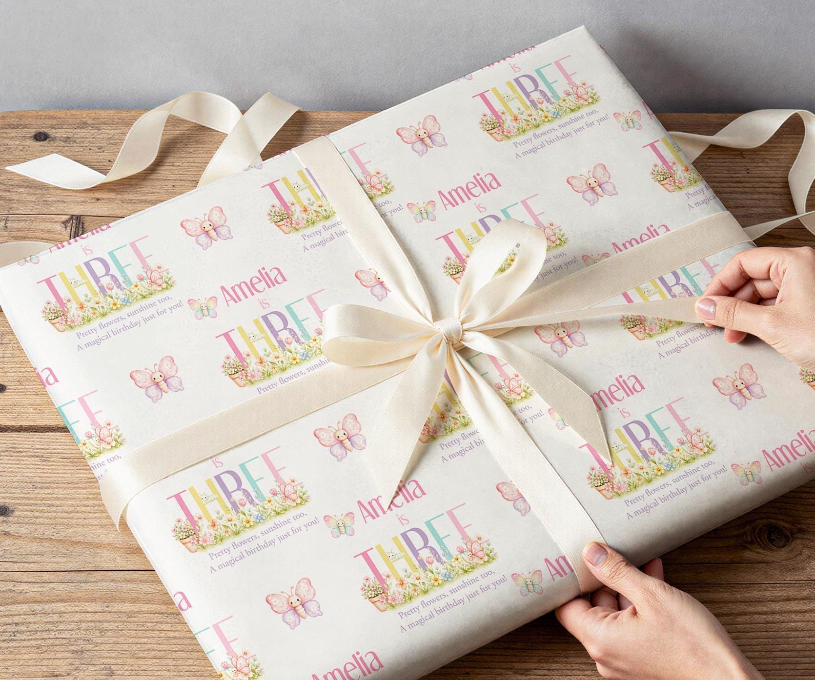 Close-up of the pastel butterfly wrapping paper pattern showing the personalised name and age detail.