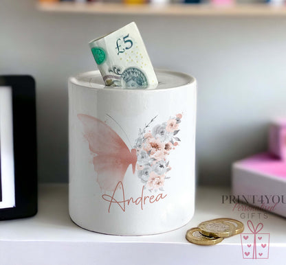 Close-up of the watercolour butterfly and floral design on the personalised ceramic money box, with the name Andrea in pink script