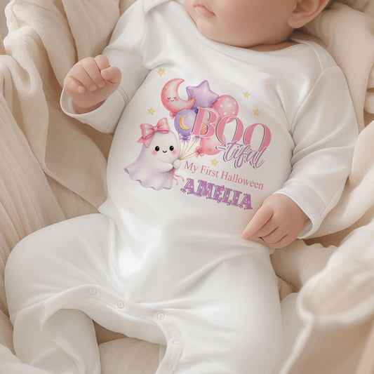 Personalised baby’s first Halloween white sleepsuit featuring a cute pastel ghost holding pink and purple balloons, stars and baby’s name.