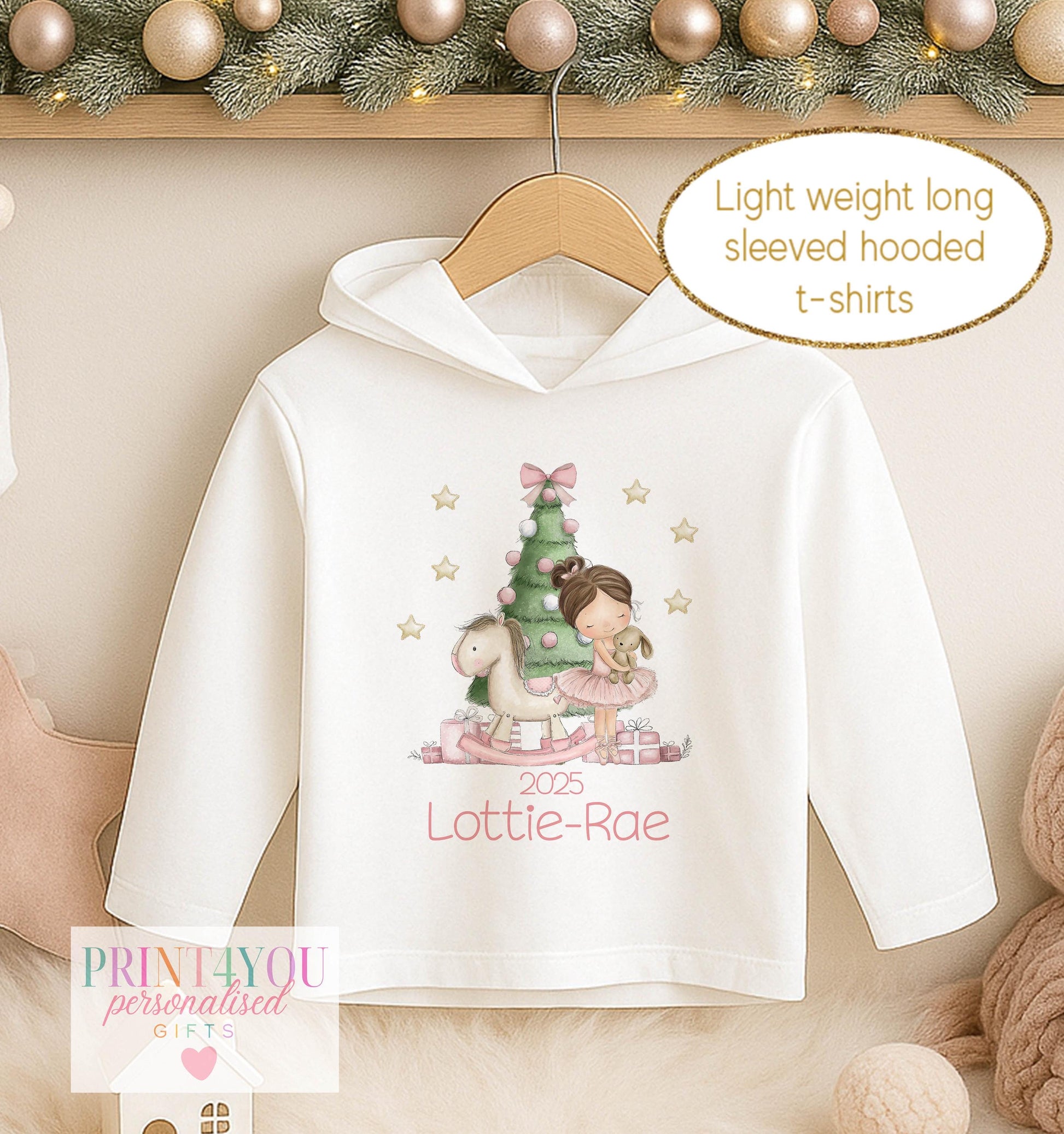 Personalised Christmas hooded t-shirt for girls, white long sleeved hoodie printed with a ballerina in a green tutu beside a Christmas tree and a name