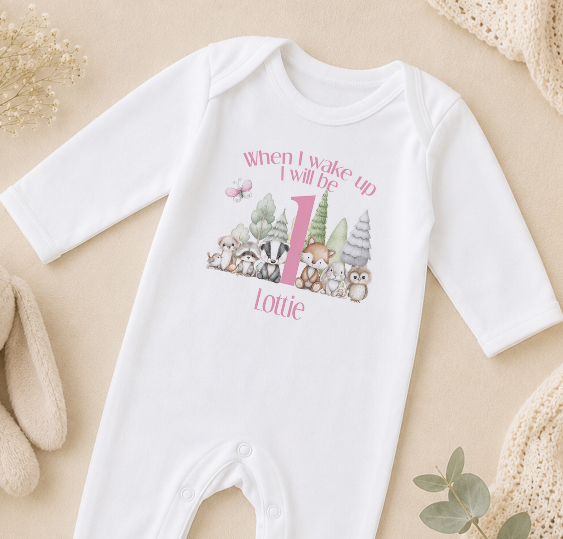 A white onesie with a personalized print of woodland animals and the text "When I wake up I will be Lottie" printed on it.