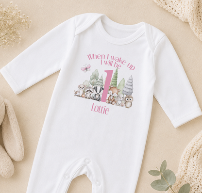 A white onesie with a personalized print of woodland animals and the text "When I wake up I will be Lottie" printed on it.