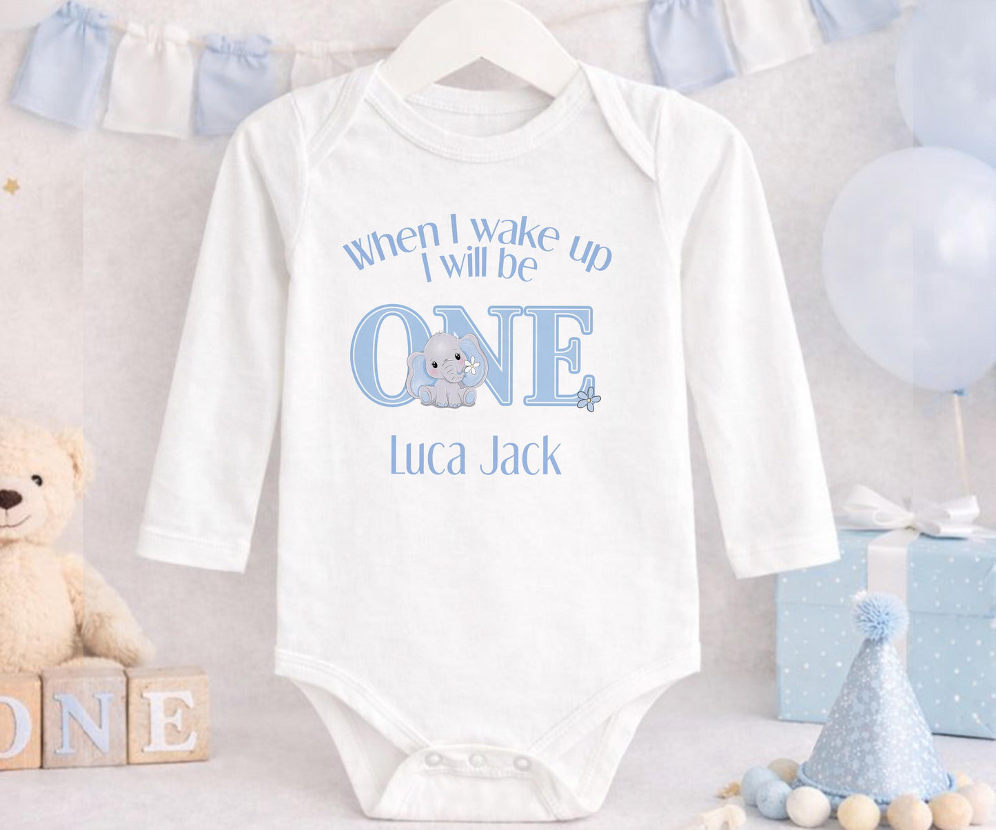 Personalised first birthday sleepsuit with blue elephant design and custom name print.