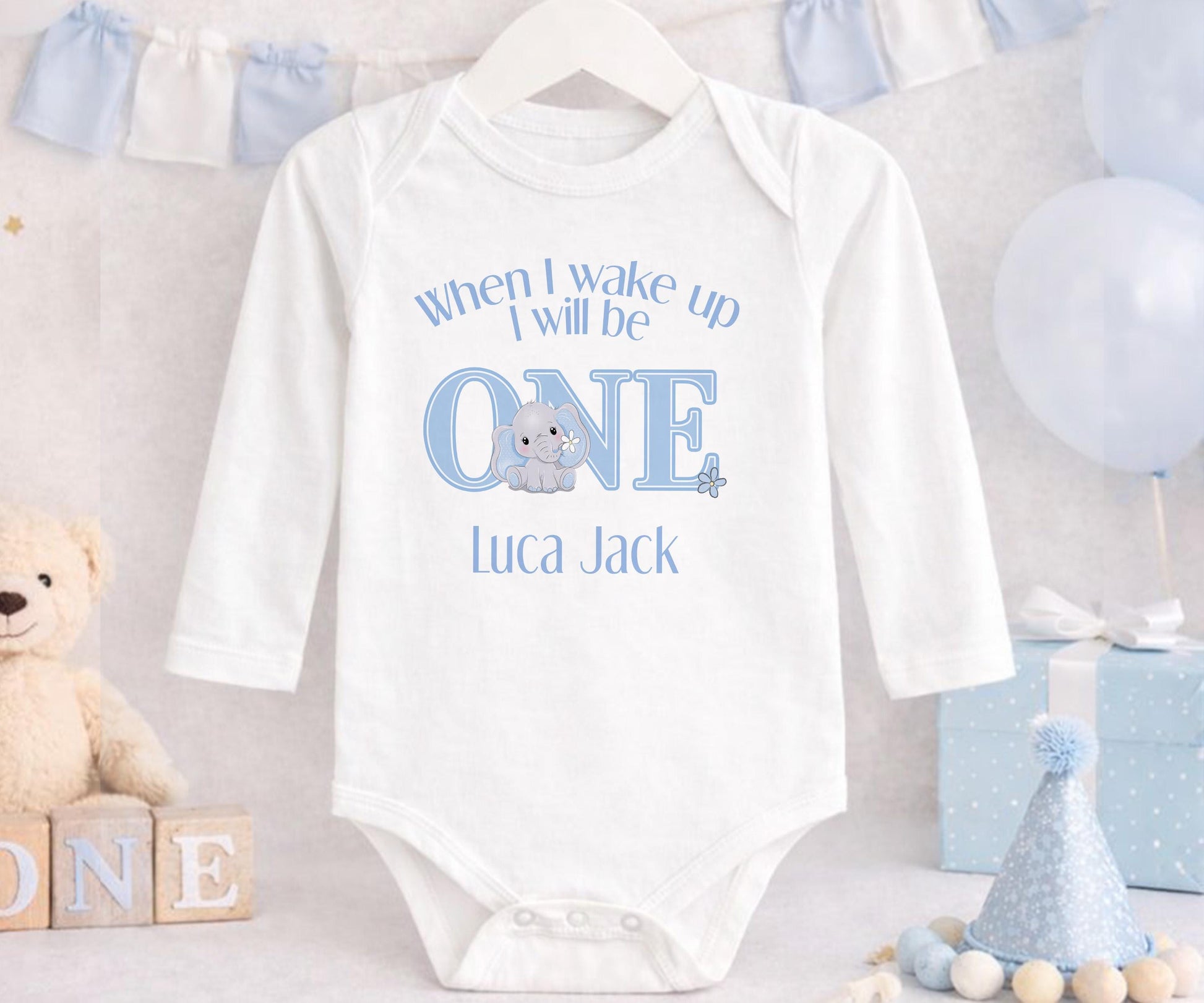 Personalised first birthday sleepsuit with blue elephant design and custom name print.