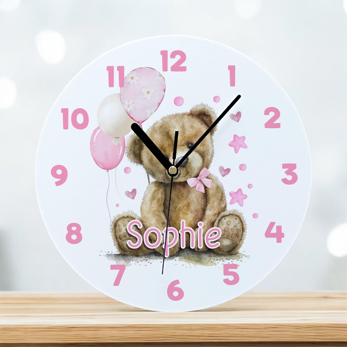 Personalised pink teddy bear acrylic wall clock with balloons and a custom child's name, 24.5cm diameter.