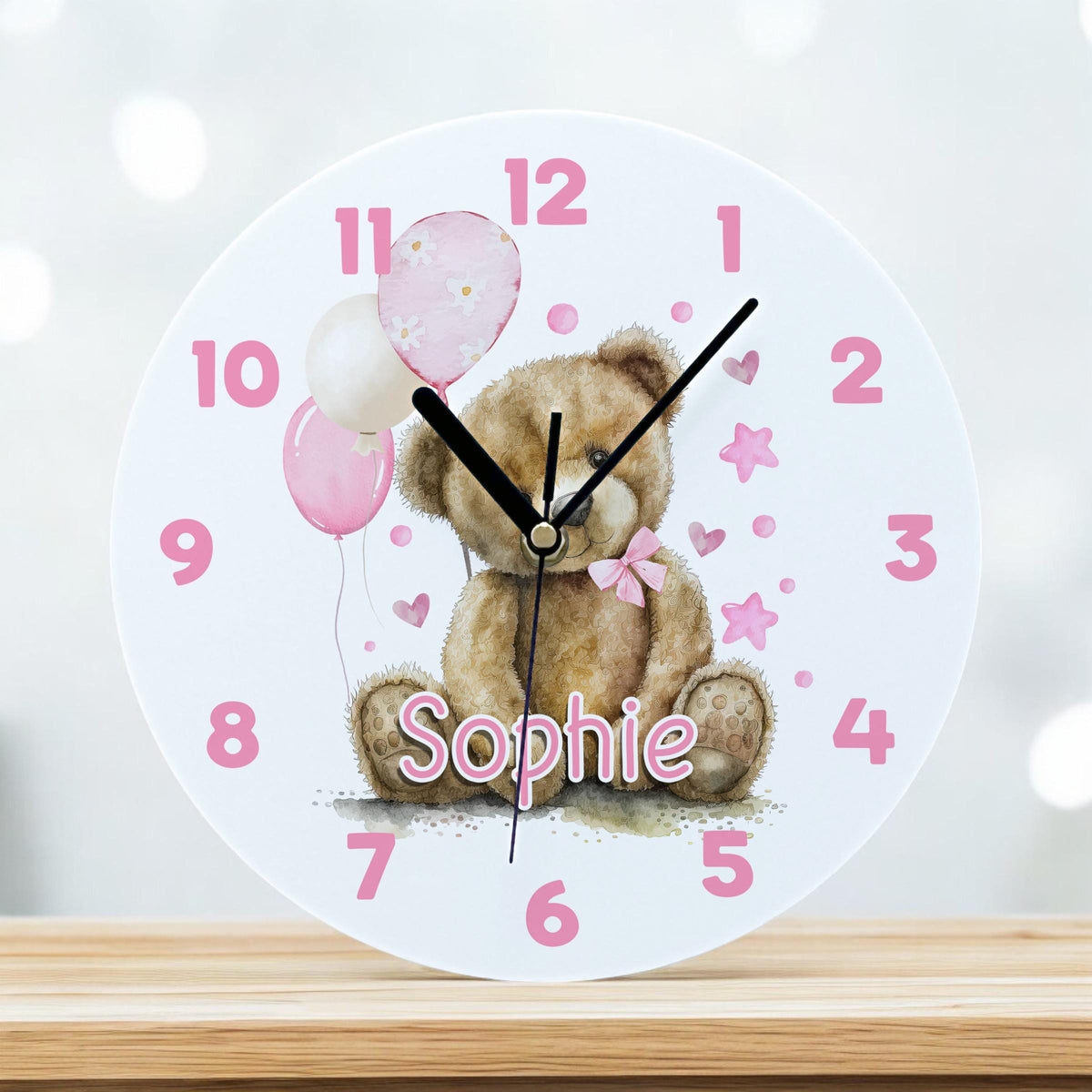 Personalised pink teddy bear acrylic wall clock with balloons and a custom child's name, 24.5cm diameter.