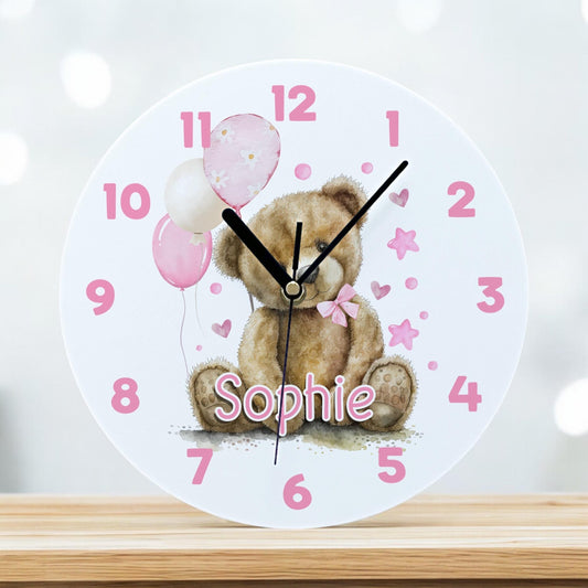 Personalised pink teddy bear acrylic wall clock with balloons and a custom child's name, 24.5cm diameter.