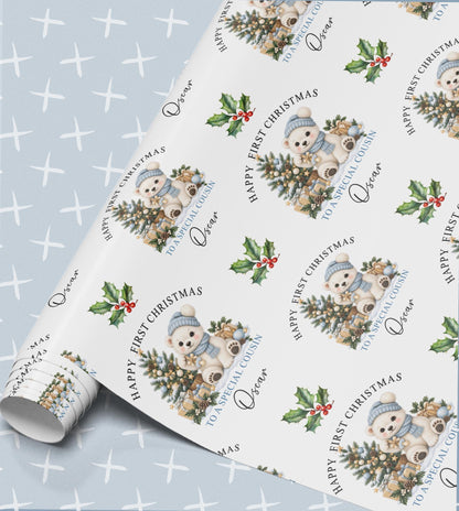 Personalised baby's first Christmas wrapping paper in pale blue with a polar bear in a bobble hat, Christmas tree and holly, relation and name
