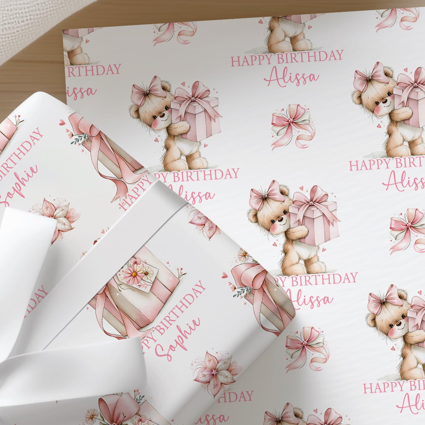 Roll of personalised teddy bear wrapping paper shown rolled and ready to wrap, with the repeating teddy bear and birthday pattern visible.