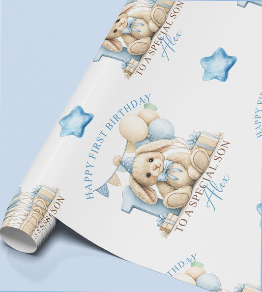 Roll of personalised first birthday wrapping paper featuring a repeating blue bunny, number one and balloon design.