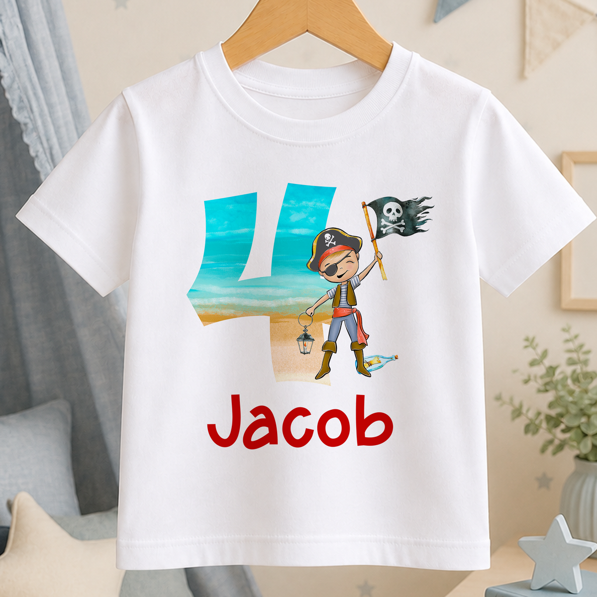 A white t-shirt with a pirate-themed design, including a character holding a pirate flag and the number "4" in the center. The text "Jacob" is printed below the design.