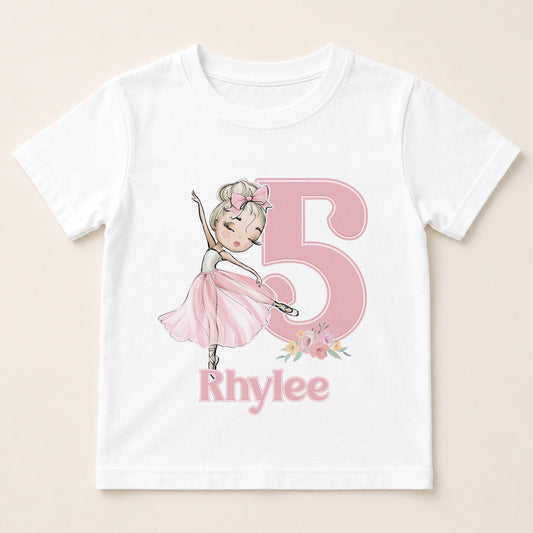 A white t-shirt with a pink illustration of a young girl dancing and the number 5 in pink. Below the number, the name "Rhylee" is written.