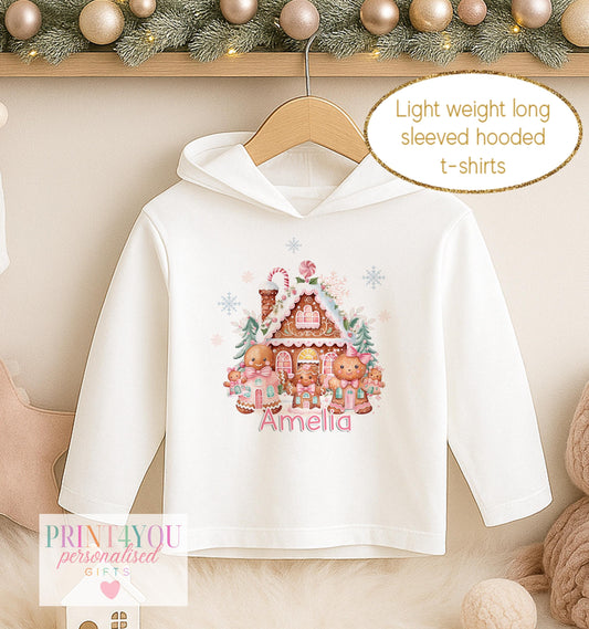 Personalised Christmas hooded t-shirt for girls, white long sleeved hoodie printed with a decorated gingerbread house and a name