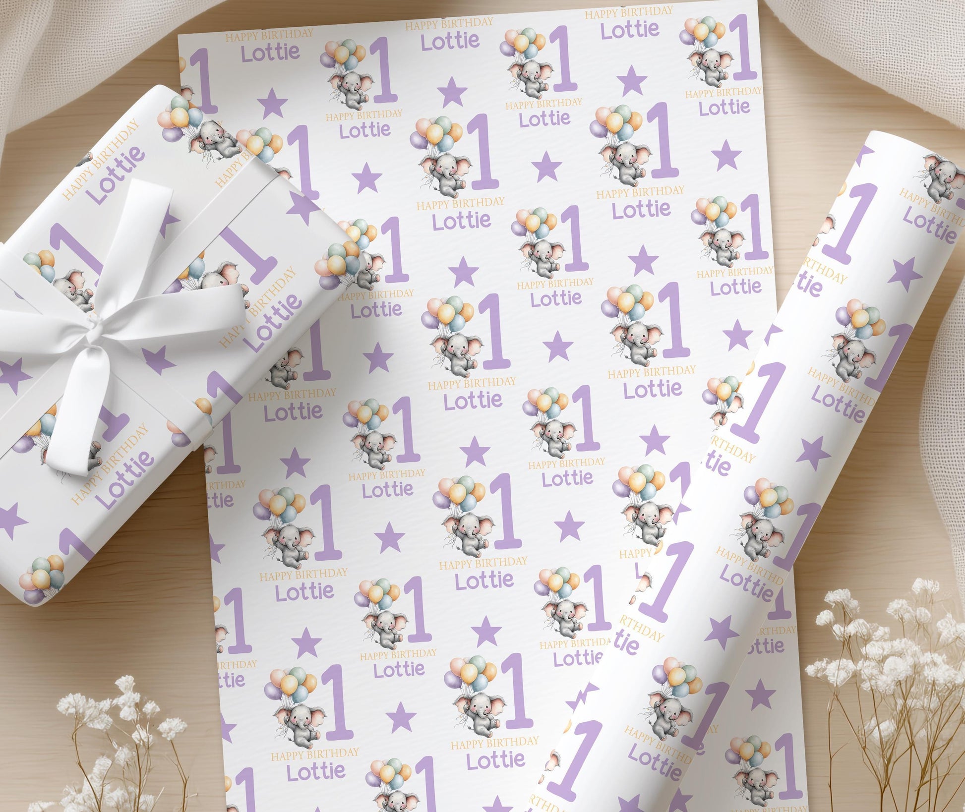 Repeating pattern of purple elephant birthday wrapping paper with the name Lottie printed in different sizes among balloons.