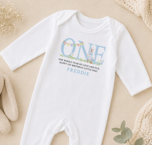 A white onesie with a personalized message printed on it, placed on a beige surface.
