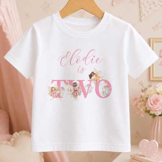 A white t-shirt with a personalized text and illustrations printed on it, hanging on a wooden hanger.