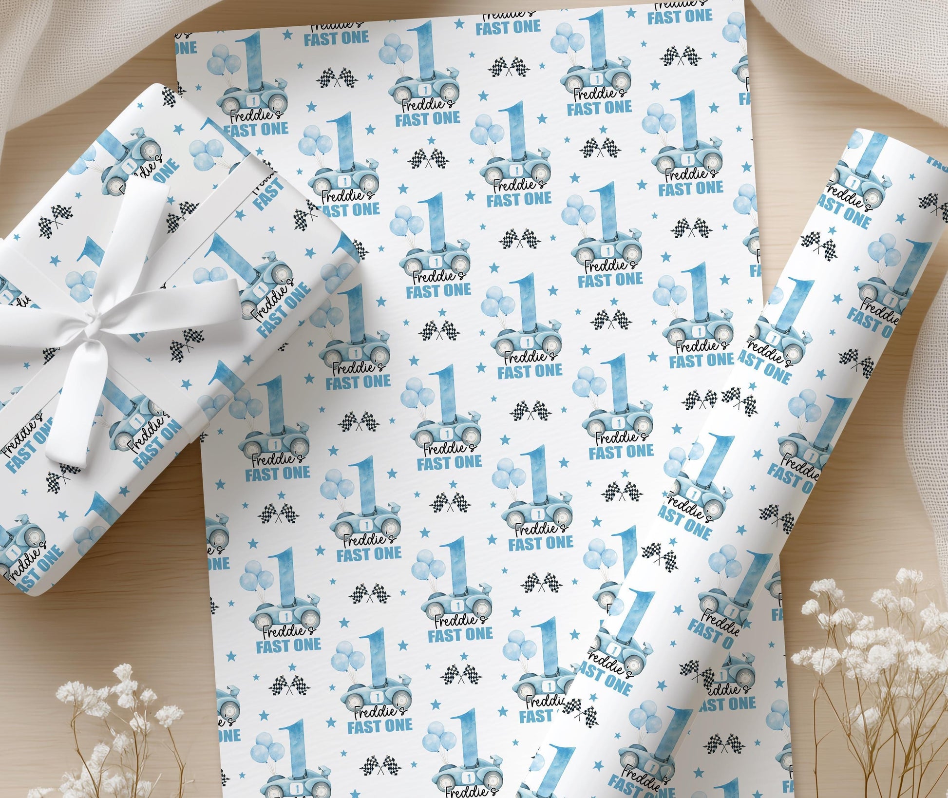 Personalised blue racing car wrapping paper sheets with a custom name printed on, laid flat on a table