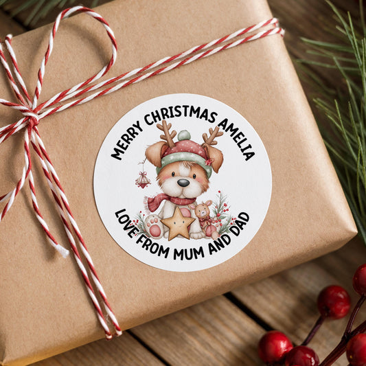 A brown gift box with a white label featuring a cartoon image of a dog wearing a Santa hat and scarf, surrounded by Christmas decorations and berries.
