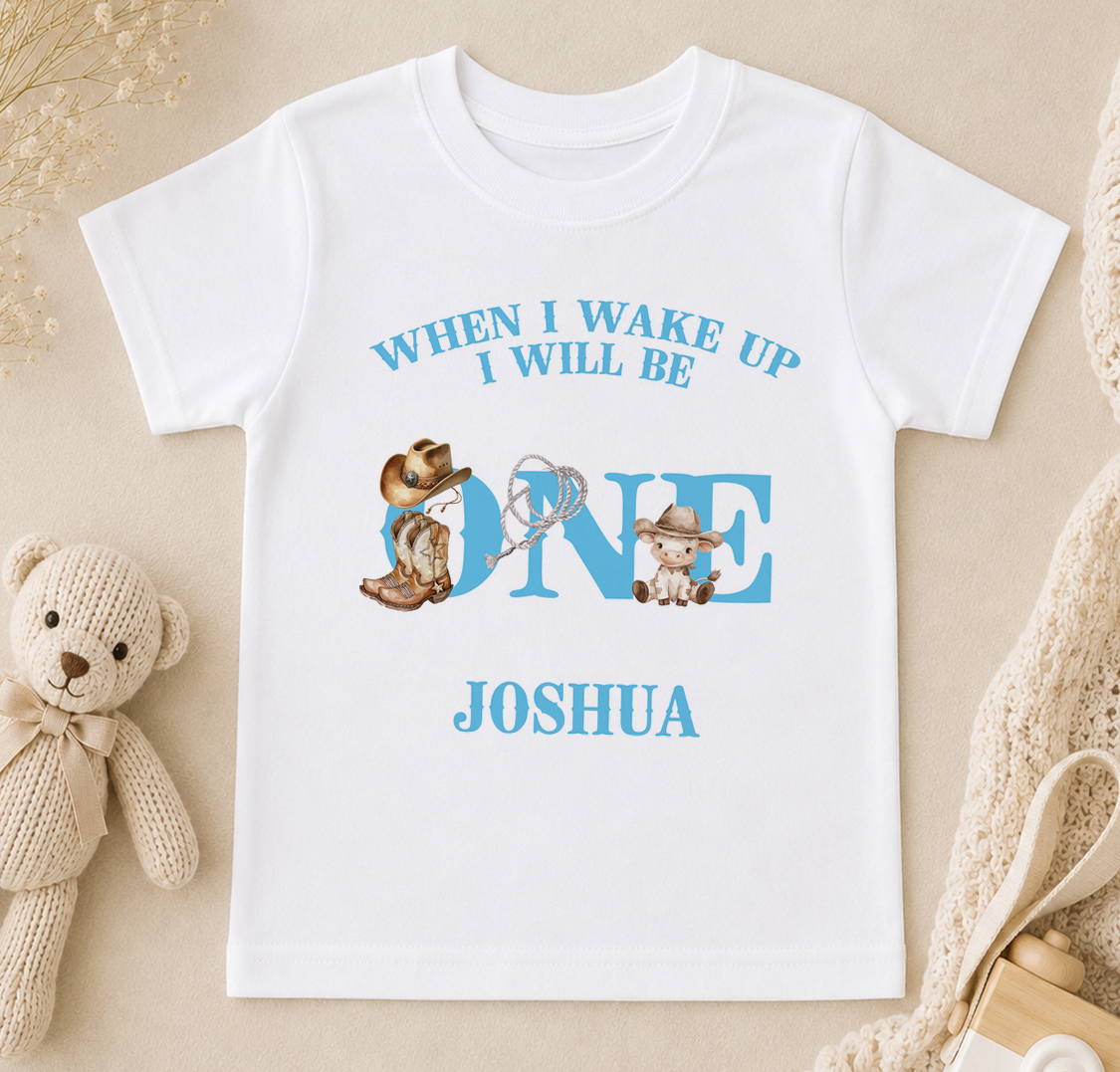 A white t-shirt with a personalized message and illustrations of a cowboy and a baby, along with the name " Joshua" printed on it.