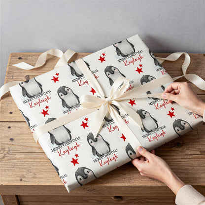 Close-up detail of the personalised penguin and red star Christmas wrapping paper design