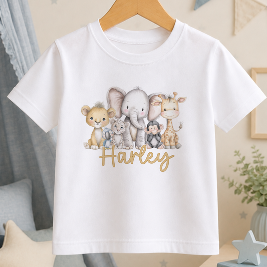 A white t-shirt with a printed design of various cartoon animals, including an elephant, lion, giraffe, and monkey, along with the name "Harley" written on it.