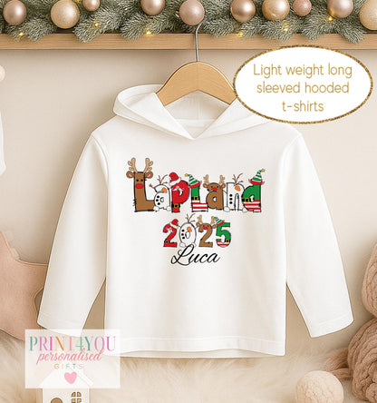 Personalised Lapland Christmas hooded t-shirt, white long sleeved hoodie printed with illustrated Lapland lettering, the year and a name