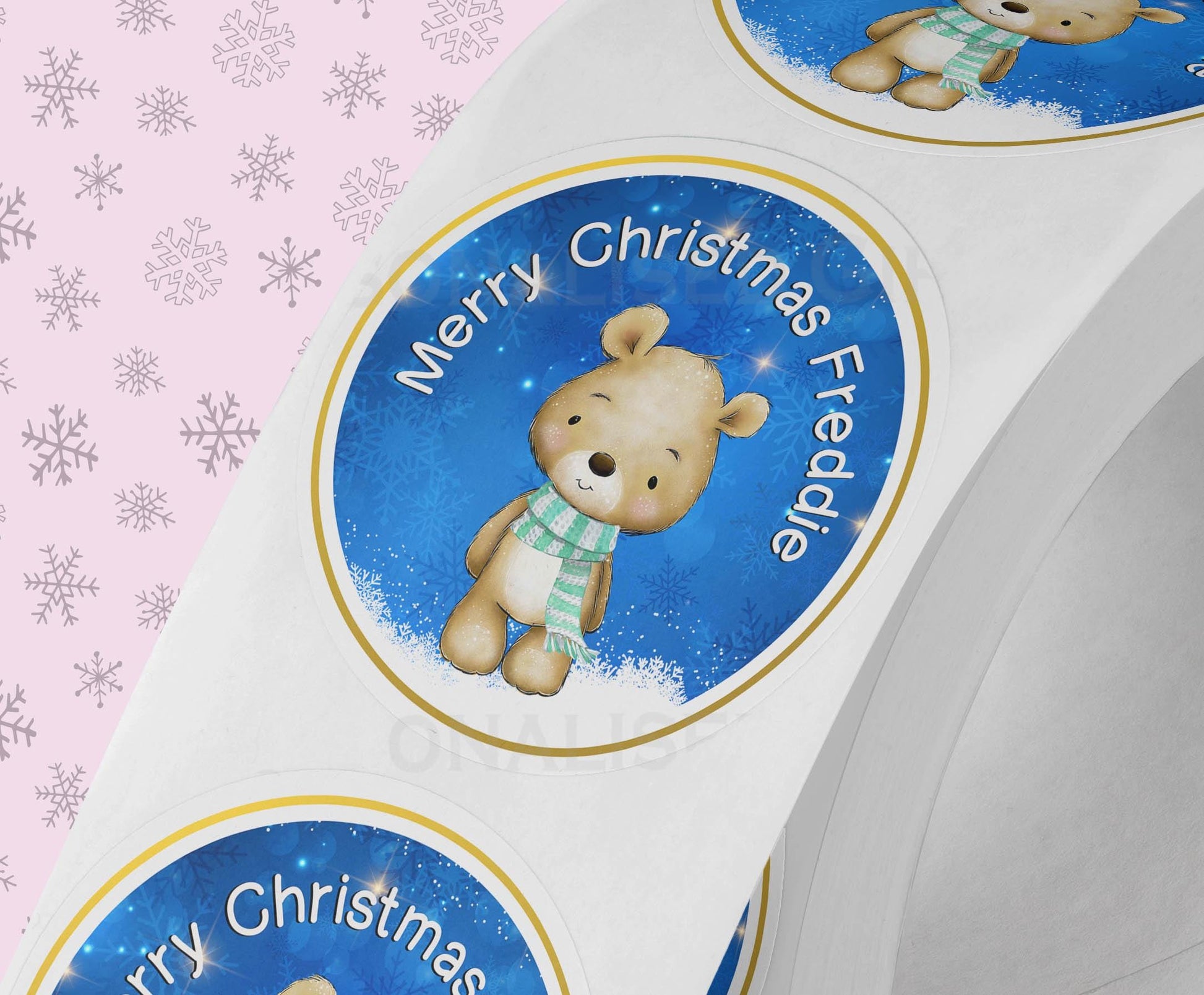 Personalised Father Christmas sticker with a custom name, shown stuck onto wrapped festive gift packaging