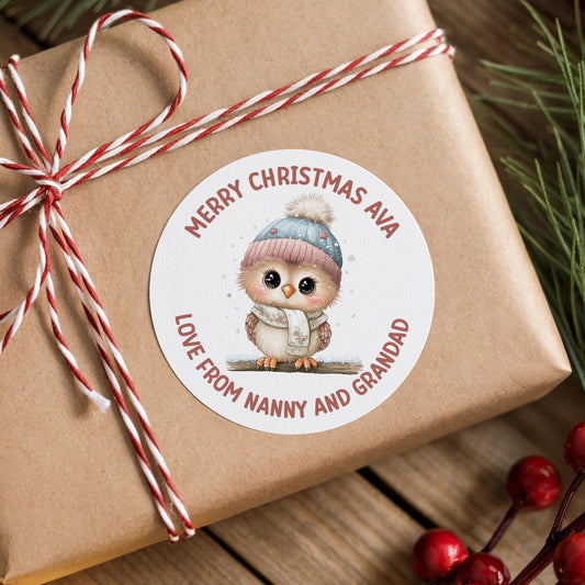 Brown gift box finished with a personalised glossy round owl Christmas sticker in a winter hat and scarf, printed with a custom name
