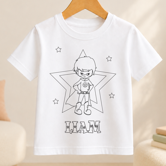 A white t-shirt with a black and white illustration of a young boy wearing a superhero costume, surrounded by stars. The text "HAM" is displayed below the illustration.