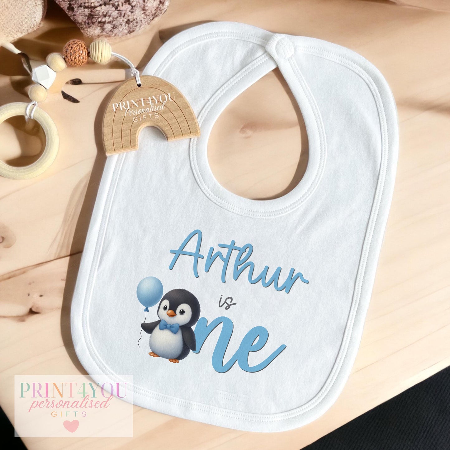 Baby boy wearing the personalised blue penguin first birthday outfit
