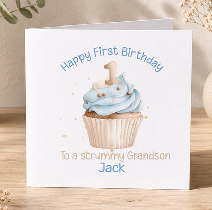 Square 1st birthday card with a blue cupcake and lit candle design, personalised with 'Happy First Birthday' and the name and relation of the recipient.