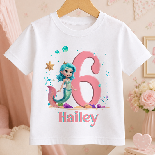 A white t-shirt with a mermaid character and the number 6 printed on it, along with the name "Haley".
