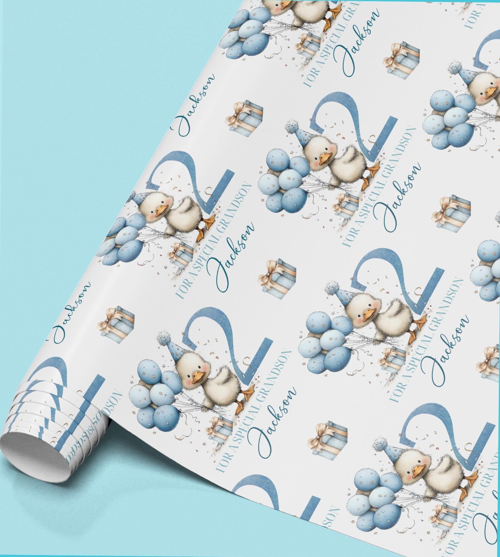 Roll of personalised blue duck birthday wrapping paper printed with the name Jackson, featuring a duck wearing a party hat and holding balloons.