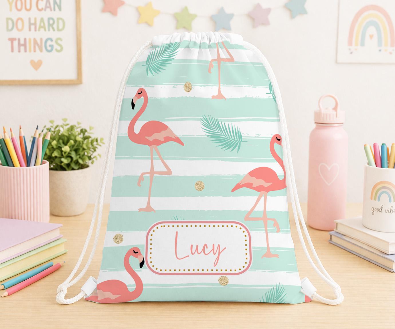 Personalised white drawstring PE bag printed with a bright pink tropical flamingo design and the child's name