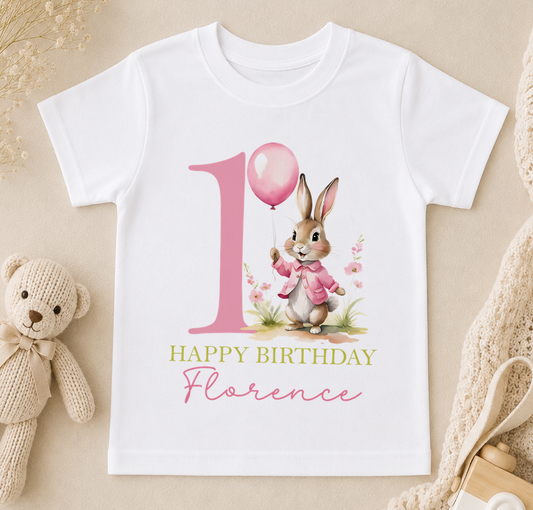 A white t-shirt with a pink bunny holding a pink balloon and the text "Happy Birthday Florence" printed on it.