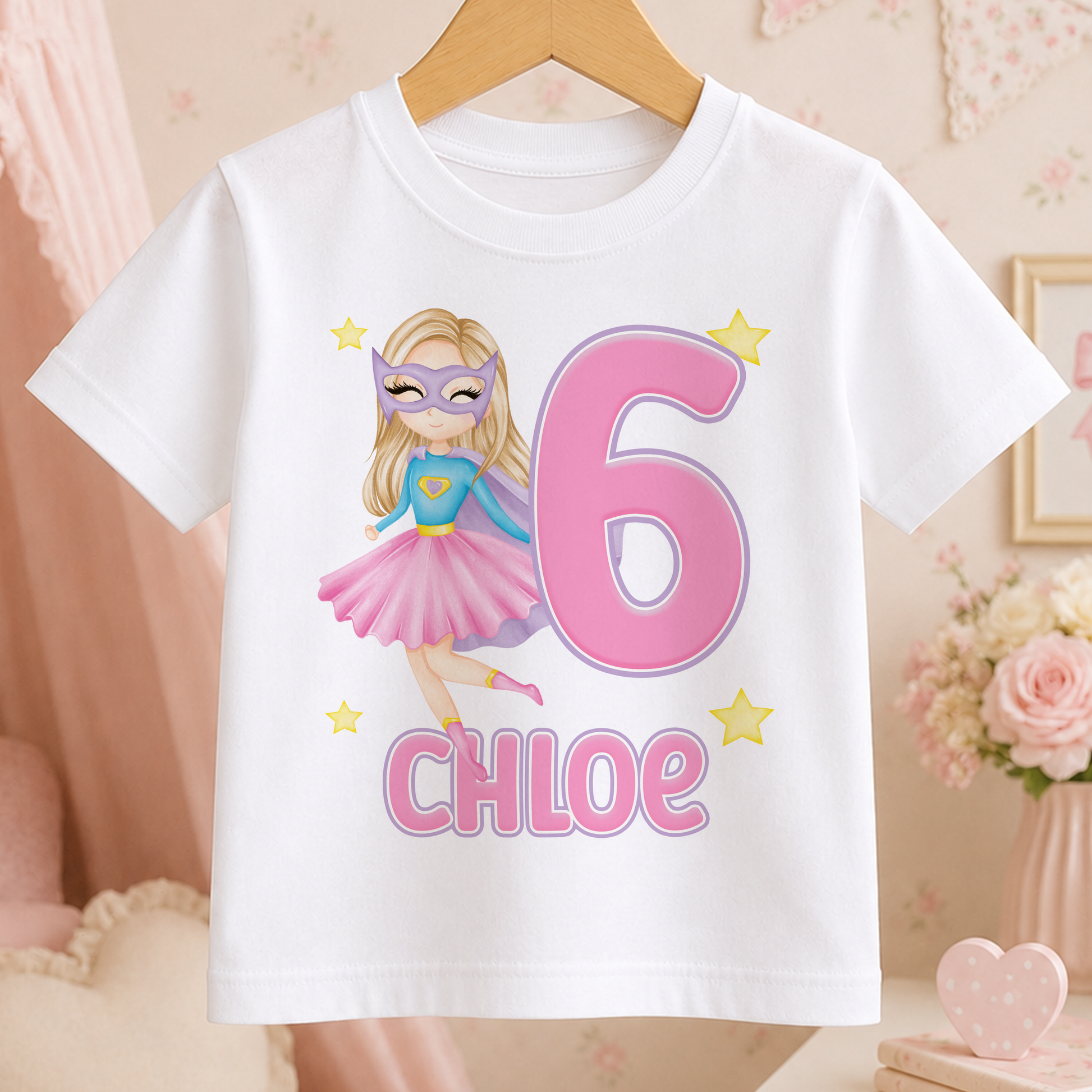 A white t-shirt with a cartoon image of a young girl wearing a superhero costume and the number 6, along with the name " Chloe" printed on it.