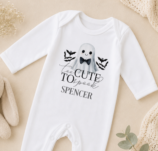 A white onesie with a graphic of a ghost and the text "Too Cute to scare" printed on it.