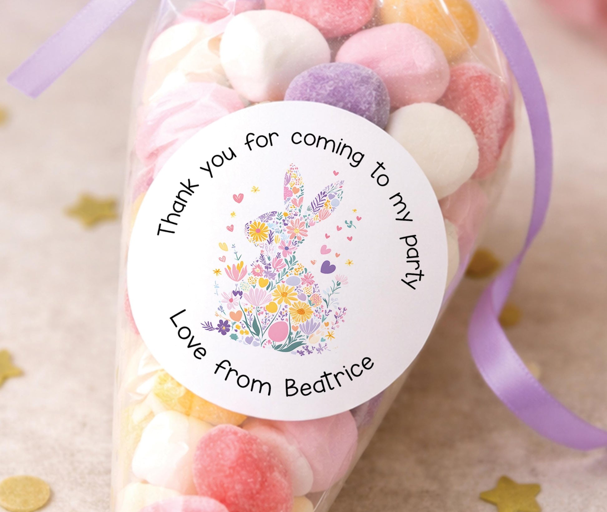 Sheet of round personalised party stickers featuring a pastel bunny and floral design with a child's name